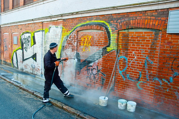 mężczyzna usuwa graffiti